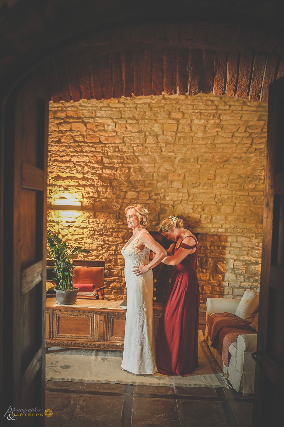 The daughter helps the mother for the dress.